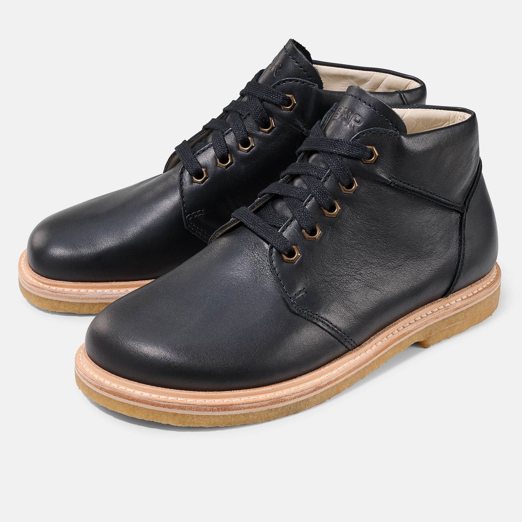 Schwarze Stiefelette für Herren. Schnürung, helle Sohle. Perspektivische Ansicht.