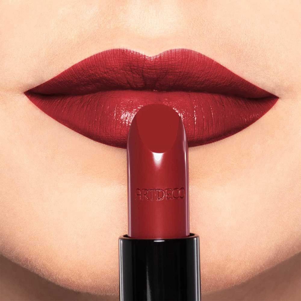 Roter Lippenstift vor roten Lippen. Auf dem Lippenstift steht "ARTDECO".