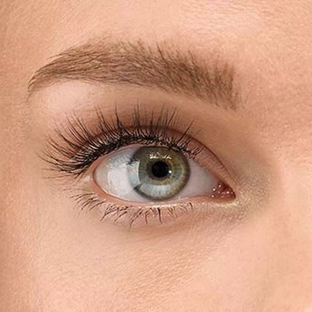 Nahaufnahme eines Auges mit angebrachten falschen Wimpern. Die Wimpern sind schwarz und verlängern die natürlichen Wimpern.