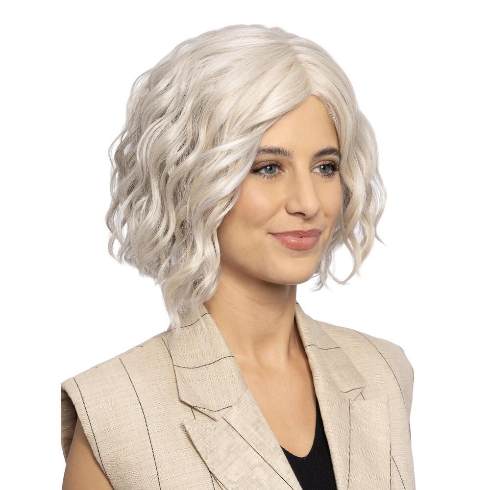 Frau mit hellgrauem, gewelltem Haarteil. Sie trägt einen Blazer.