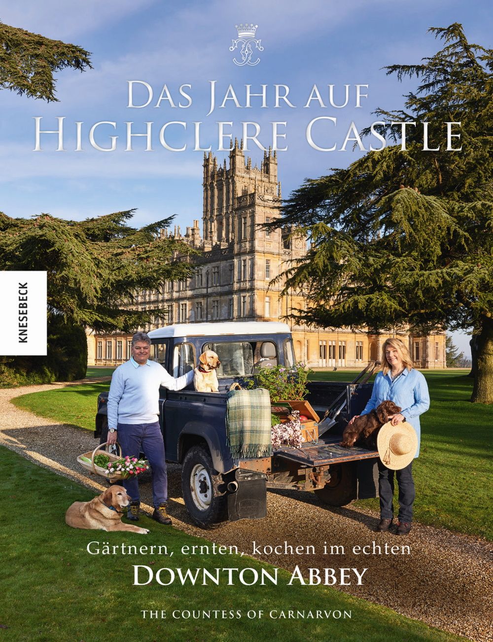 Buchcover mit Titel "Das Jahr auf Highclere Castle". Personen und Hunde vor einem Schloss und einem Fahrzeug. Text: Gärtnern, ernten, kochen im echten Downton Abbey.