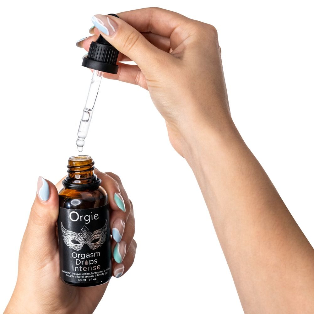 Hände halten eine braune Glasflasche mit schwarzem Deckel und Pipette. Aufschrift: Orgie, Orgasm Drops Intense.