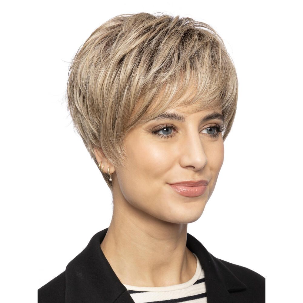 Kurzhaarperücke in Blondtönen. Nahaufnahme einer Frau mit Perücke. Kurzer, fransiger Pony. Die Frau trägt einen schwarzen Blazer.