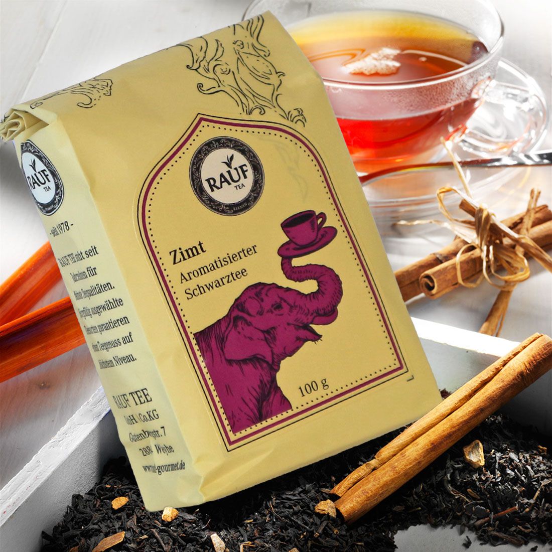 Rauf Tee-Beutel mit Zimt, aromatisierter Schwarztee, lila Elefant, Tasse. Zimtstangen, Teeblätter, Glasbecher Tee.