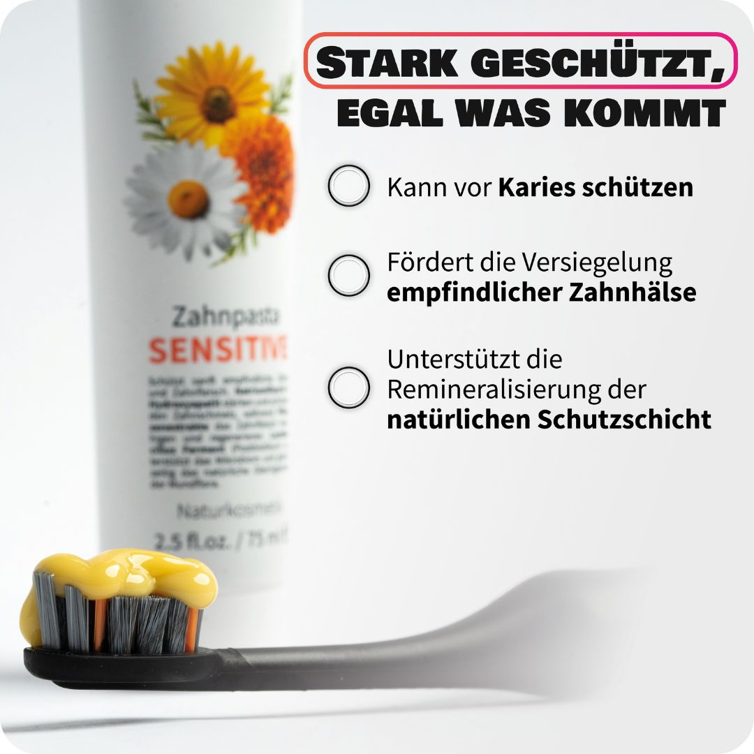 Zahnheld Zahnpasta Sensitive Tube neben einer Zahnbürste mit gelber Zahnpasta.