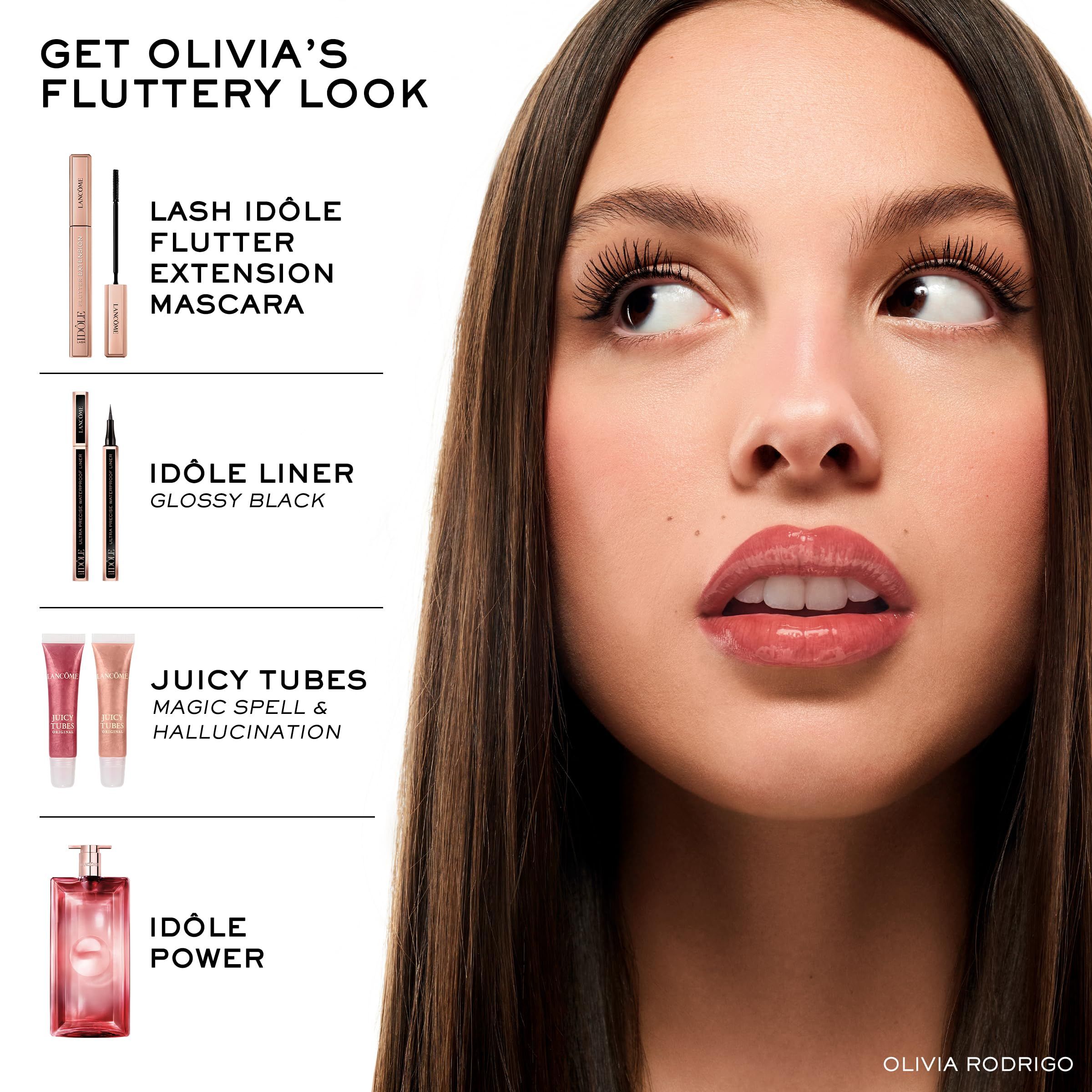 Frau mit Make-up-Produkten. Mascara, Eyeliner, Lipgloss, Parfüm. Text: Get Olivia's Fluttery Look.