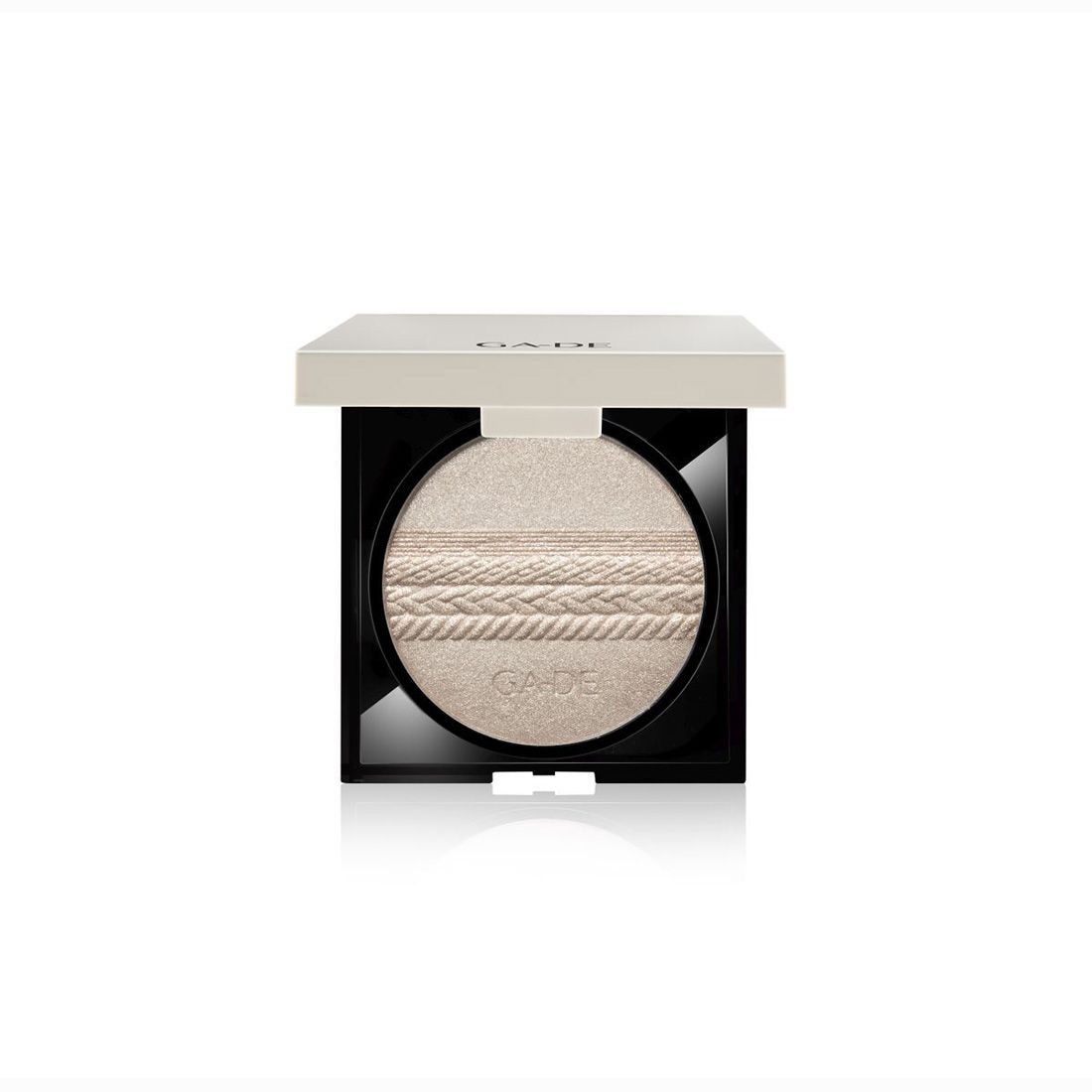 Quadratische Kosmetikdose mit hellem Puder. Der Deckel ist hellbeige, die Dose schwarz. Der Puder hat ein geflochtenes Muster.