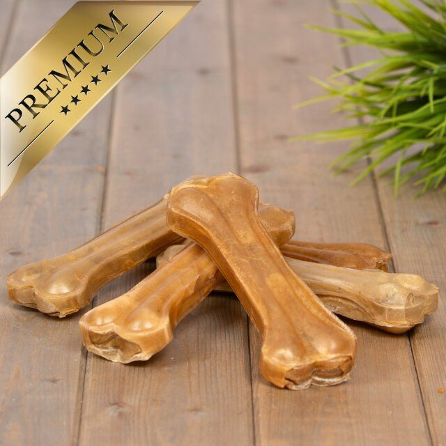 Mehrere Lyra Pet Kauknochen auf Holz. Aufschrift: PREMIUM.