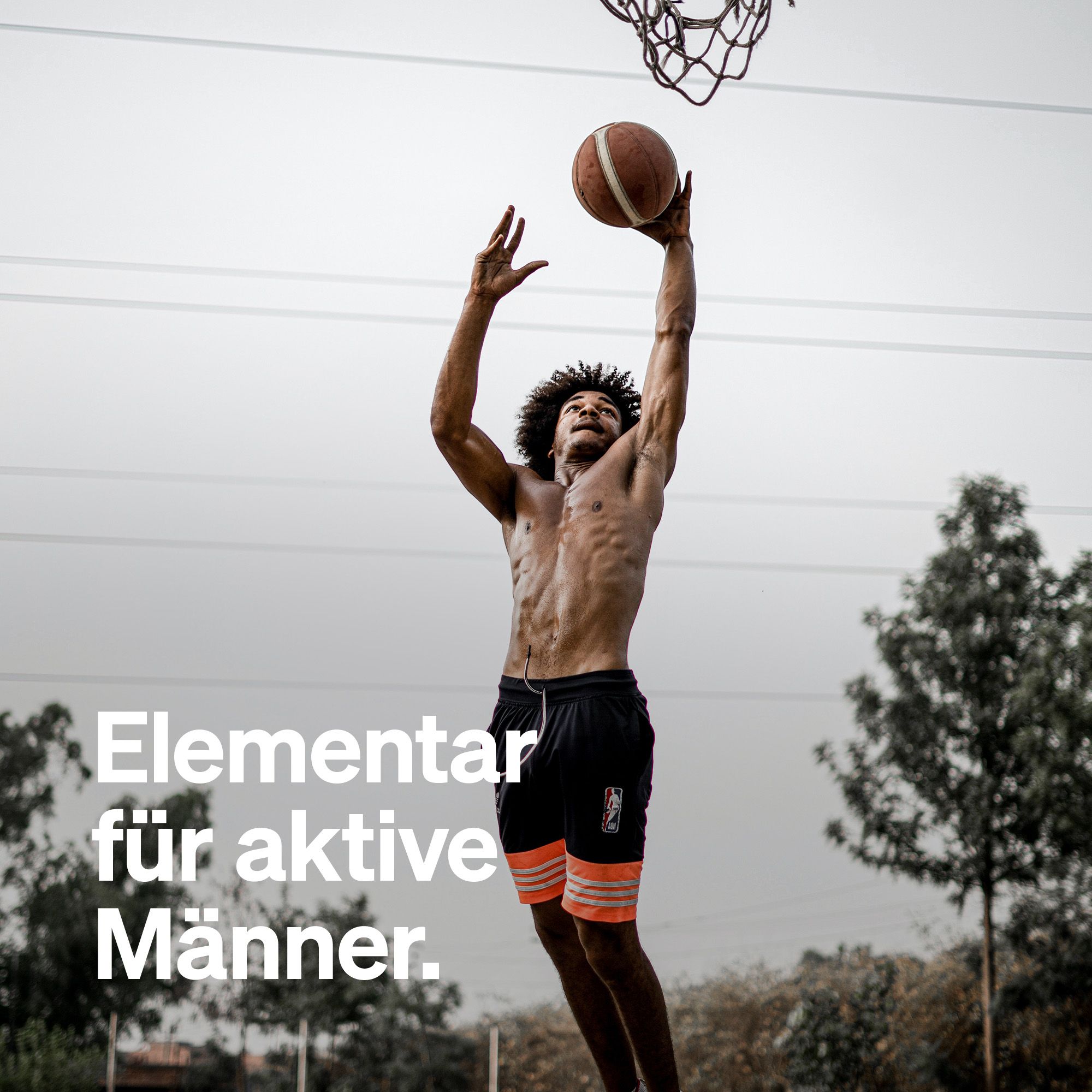 Mann wirft Basketball in den Korb. Text: Elementar für aktive Männer.