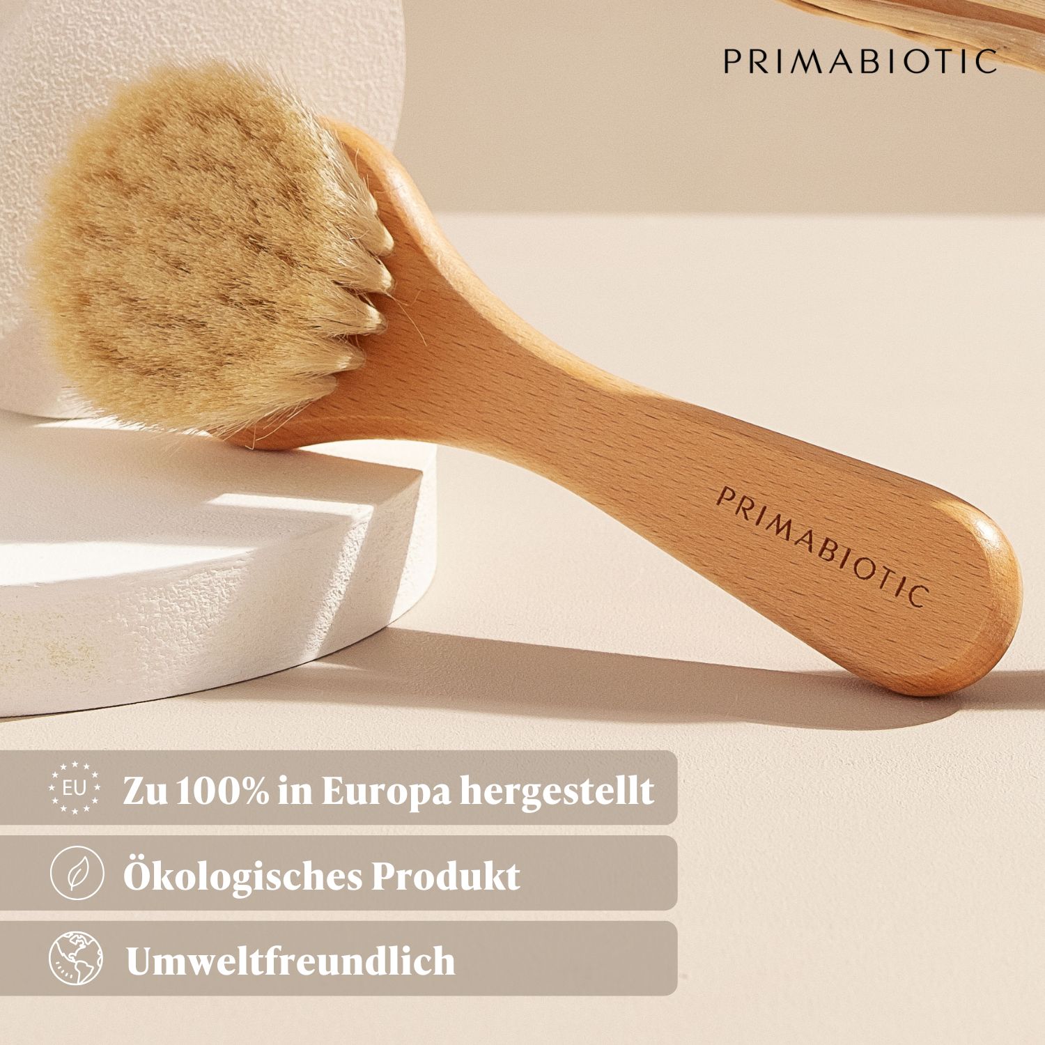 Gesichtsmassagebürste mit Holzgriff und Borsten. Auf dem Griff steht PRIMABIOTIC. Text: Hergestellt in Europa, ökologisches Produkt, umweltfreundlich.