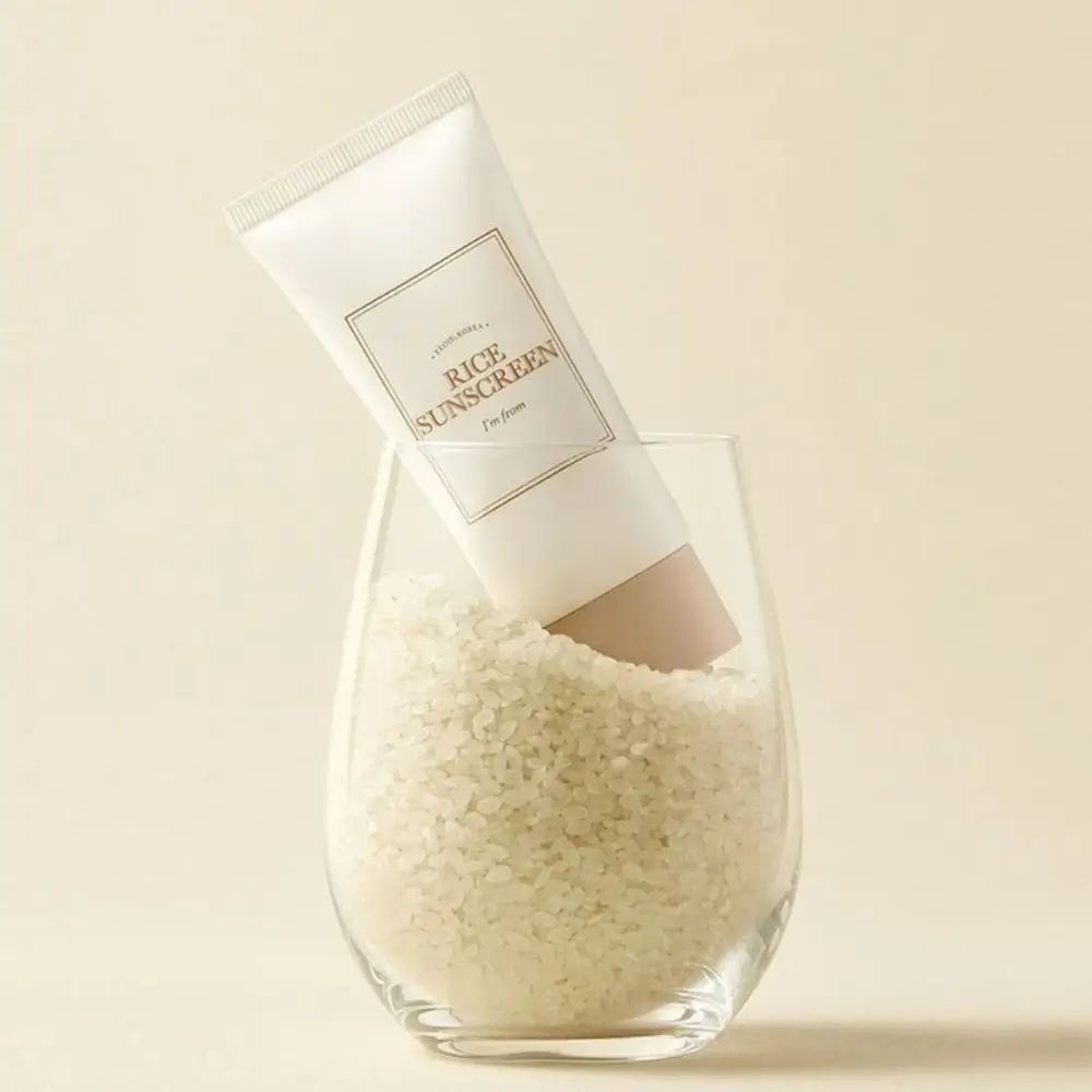 Creme-Tube in Glas mit Reis. Aufschrift „Rice Sunscreen“ und „I'm from“. Beige Kappe.