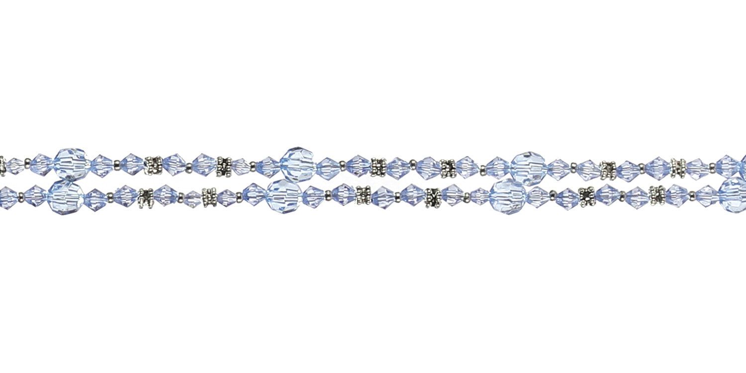 Nahaufnahme der Brillenkette mit blauen Perlen und Metallakzenten. Details der Perlenstruktur sichtbar.