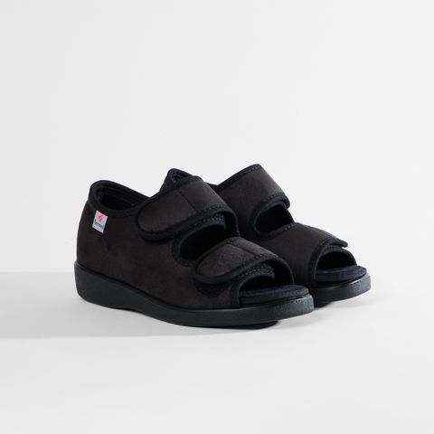 Schwarze Sandale mit Klettverschluss, offenem Zehenbereich und einem kleinen roten Logo auf der Seite.