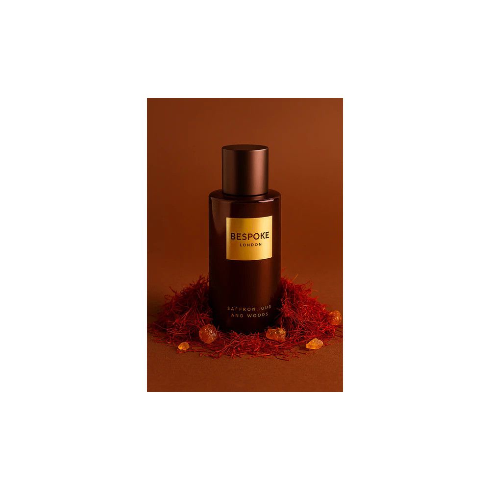 Braune Parfumflasche mit goldfarbenem Etikett, umgeben von Safranfäden und Harzstücken. Aufschrift: Bespoke London.