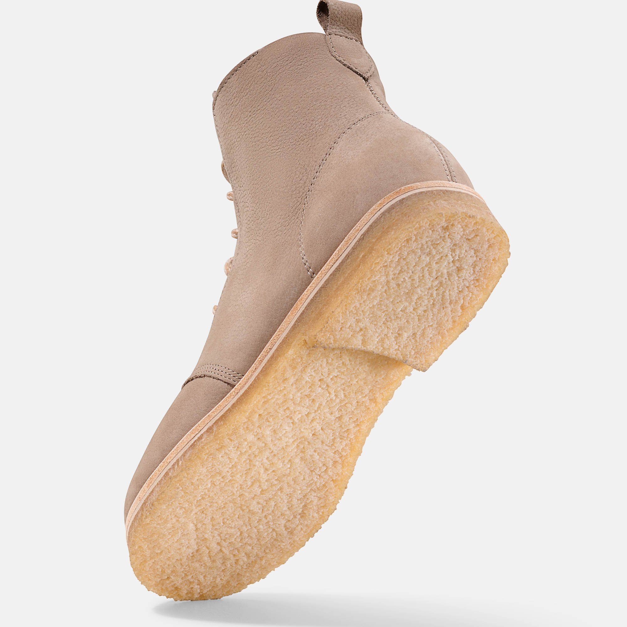 Beigefarbene Stiefelette, Unteransicht. Hellbraune Sohle, helles Leder. Flache Form, breite Passform. Perspektive.