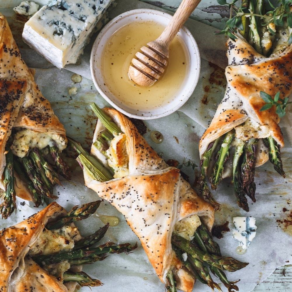 Gebäck mit Spargel, Käse und Mohnsamen. Blauschimmelkäse, Honig und Honigstab.