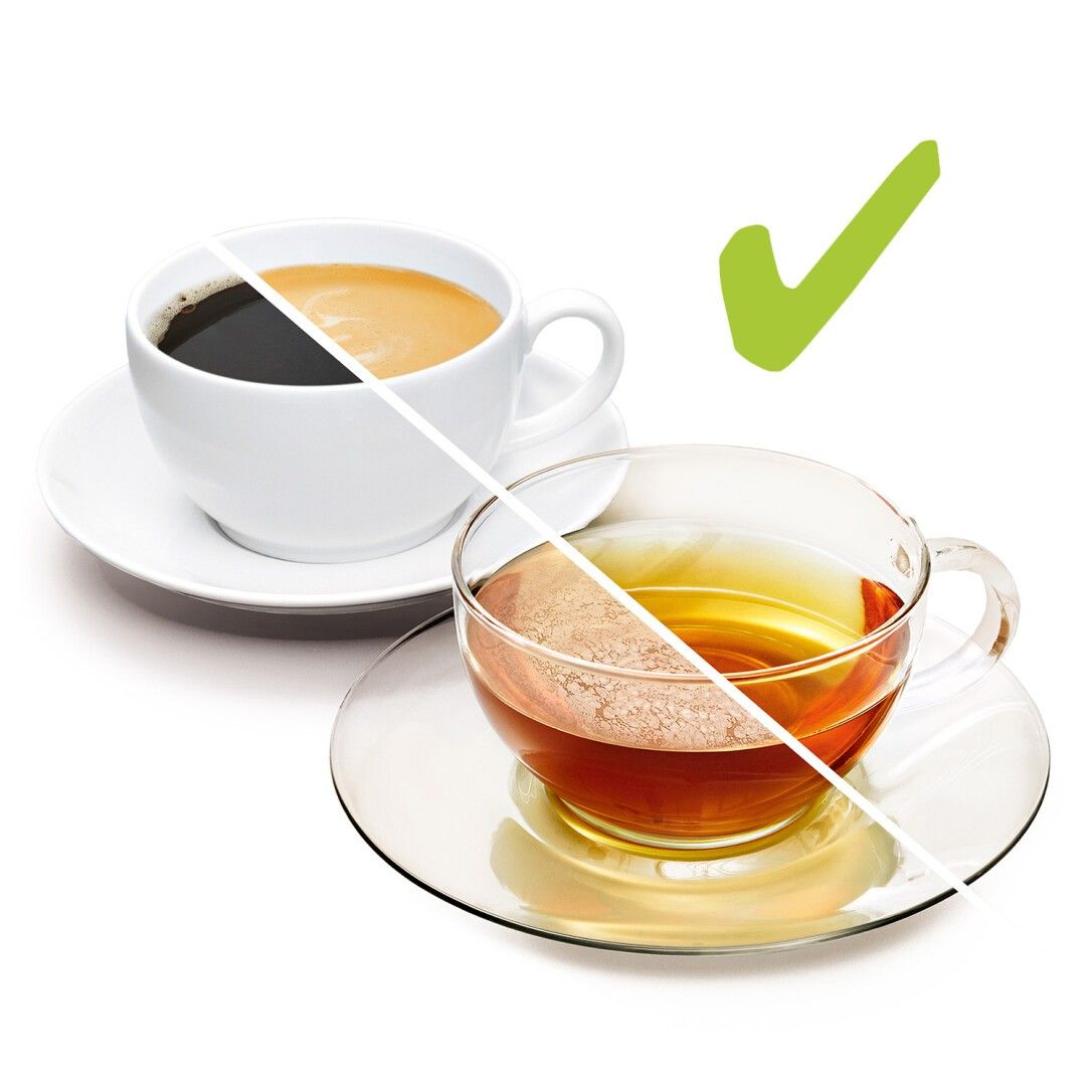 Zwei Tassen, eine mit Kaffee, eine mit Tee. Grüne Hakenmarkierung. Vergleich der Flüssigkeiten.