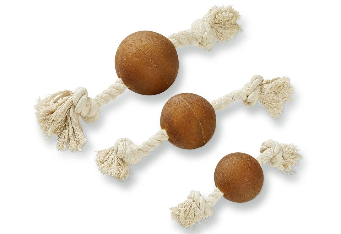 Drei Bälle aus Naturkautschuk mit Seil. Braune Kugeln mit weißem Seil verbunden, auf weißem Hintergrund.