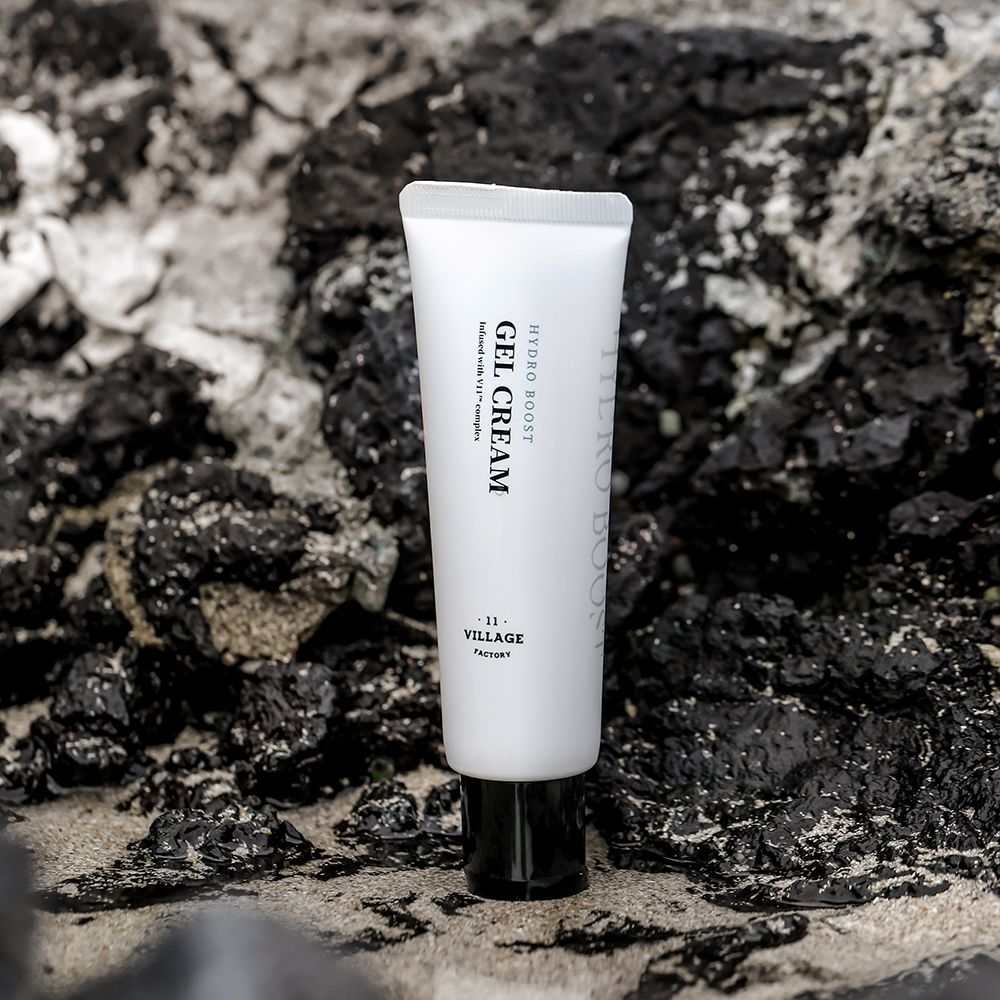 Weiße Tube mit schwarzem Deckel auf Steinen. Aufschrift: HYDRO BOOST GEL CREAM. Marke: VILLAGE 11 FACTORY.