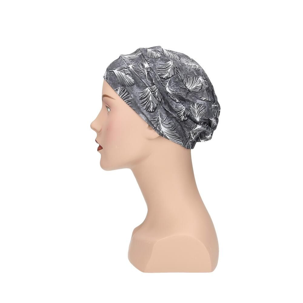 Grauer Turban mit Feder-Muster auf einer Schaufensterpuppe. Profilansicht.