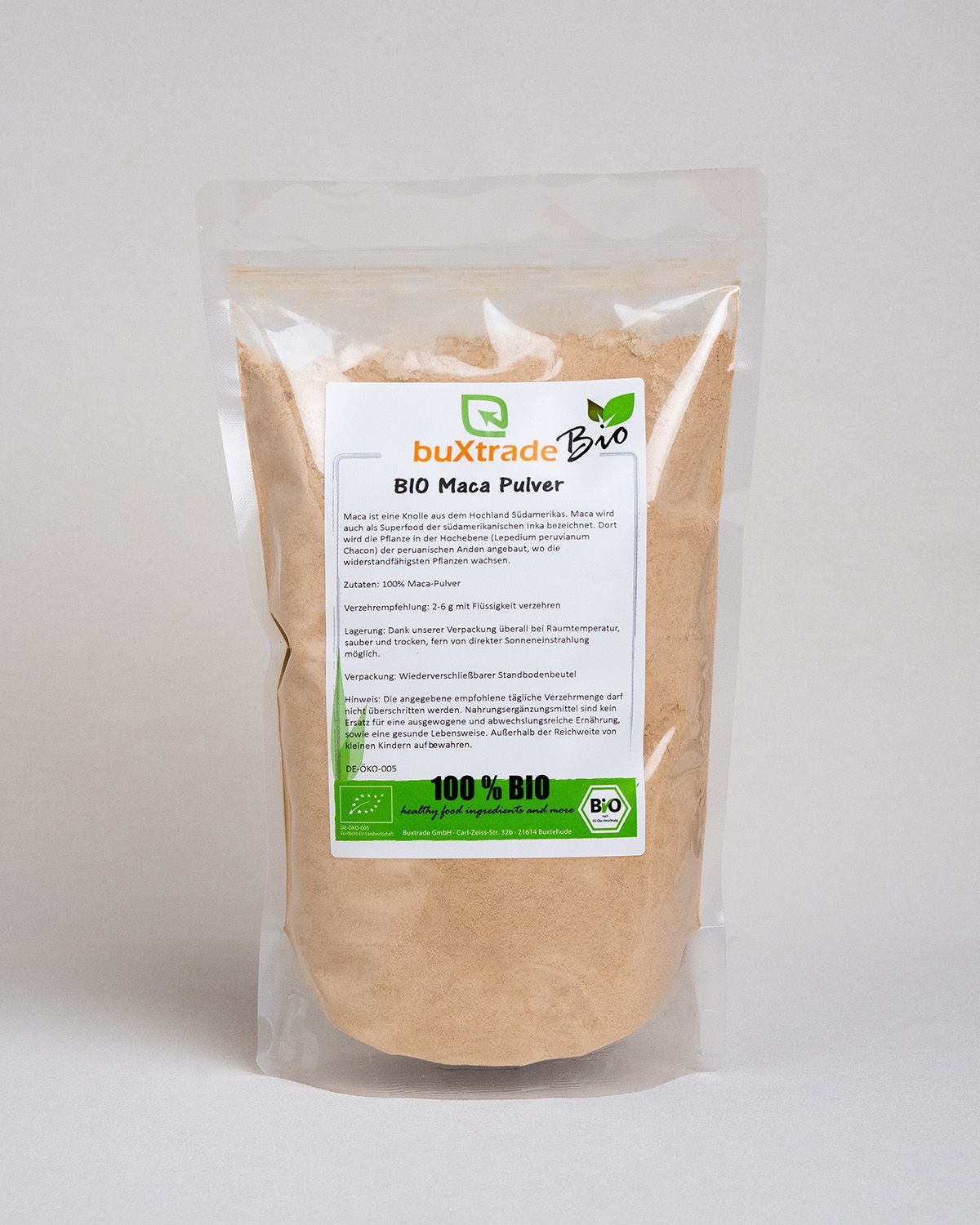 Beutel mit buXtrade Bio Maca Pulver. Transparente Verpackung, weißes Etikett mit Text und Logo. Bio-Siegel.