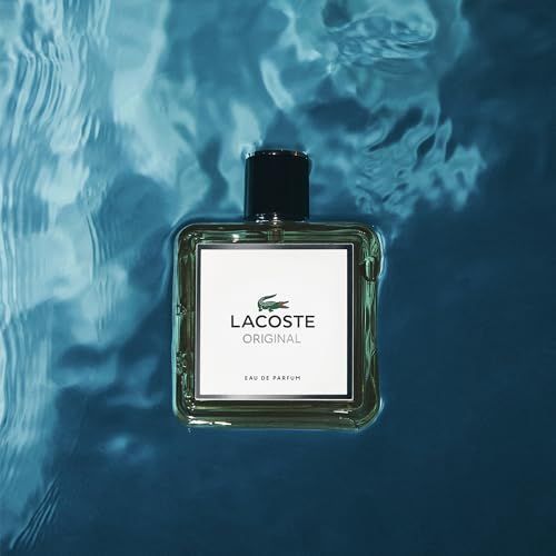 Flakon im Wasser. Quadratische Flasche mit schwarzem Verschluss. Weißes Etikett mit Logo und Schriftzug 'LACOSTE ORIGINAL'.