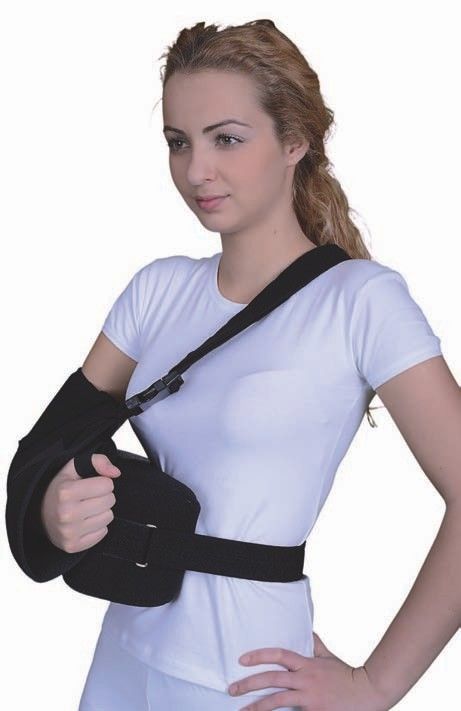 Schulterabduktionskissen mit regulierbarem Befestigungssystem. Schwarzes Kissen und Gurte, getragen von einer Person.