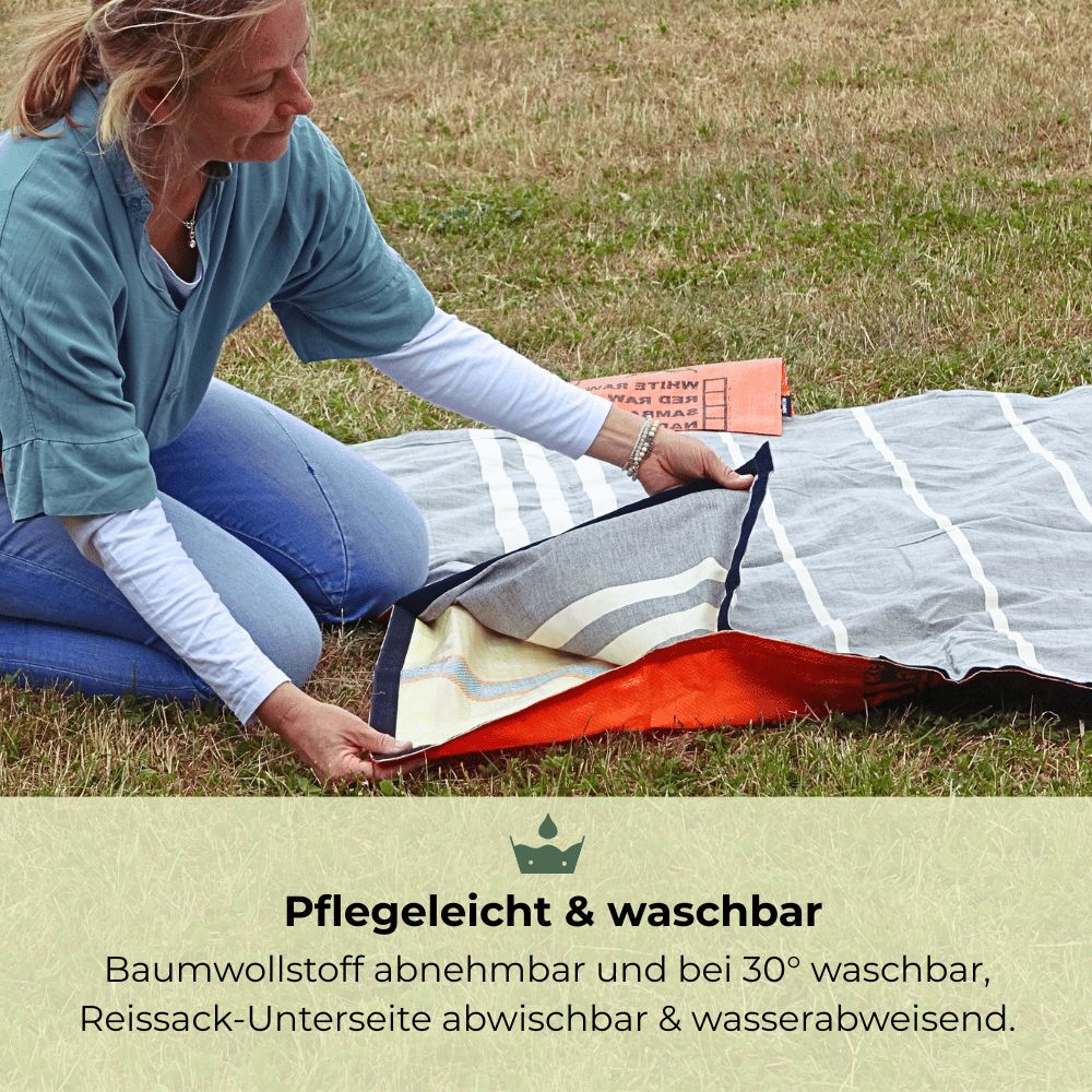 Frau falt eine Decke mit Streifenmuster, Unterseite abwischbar.