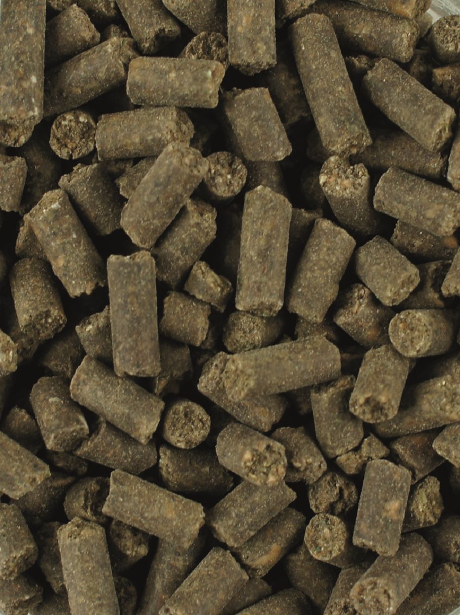 ATCOM HUF-VITAL ®. Braune, zylindrische Pellets, Nahaufnahme. Texturierte Oberfläche, unregelmäßige Form. Lose angeordnet, ohne Verpackung.