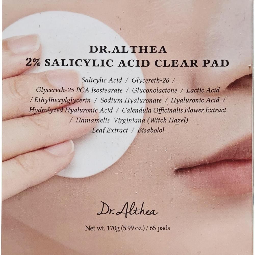 Nahaufnahme eines Dr. Althea 2% Salicylsäure Clear Pads, das von einer Hand auf ein Wattepad aufgetragen wird.