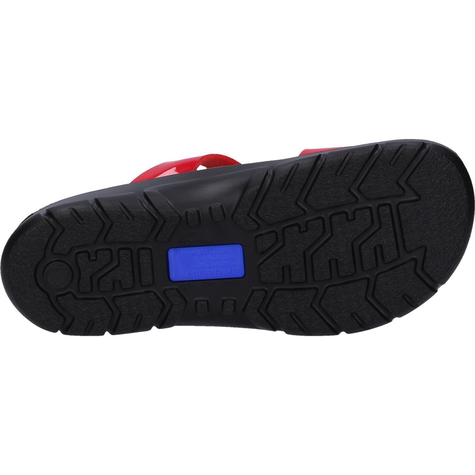 Unterseite einer schwarzen Sandale mit roter Sohle. Profilierte Sohle mit blauem Einsatz. Birkenstock-Logo.
