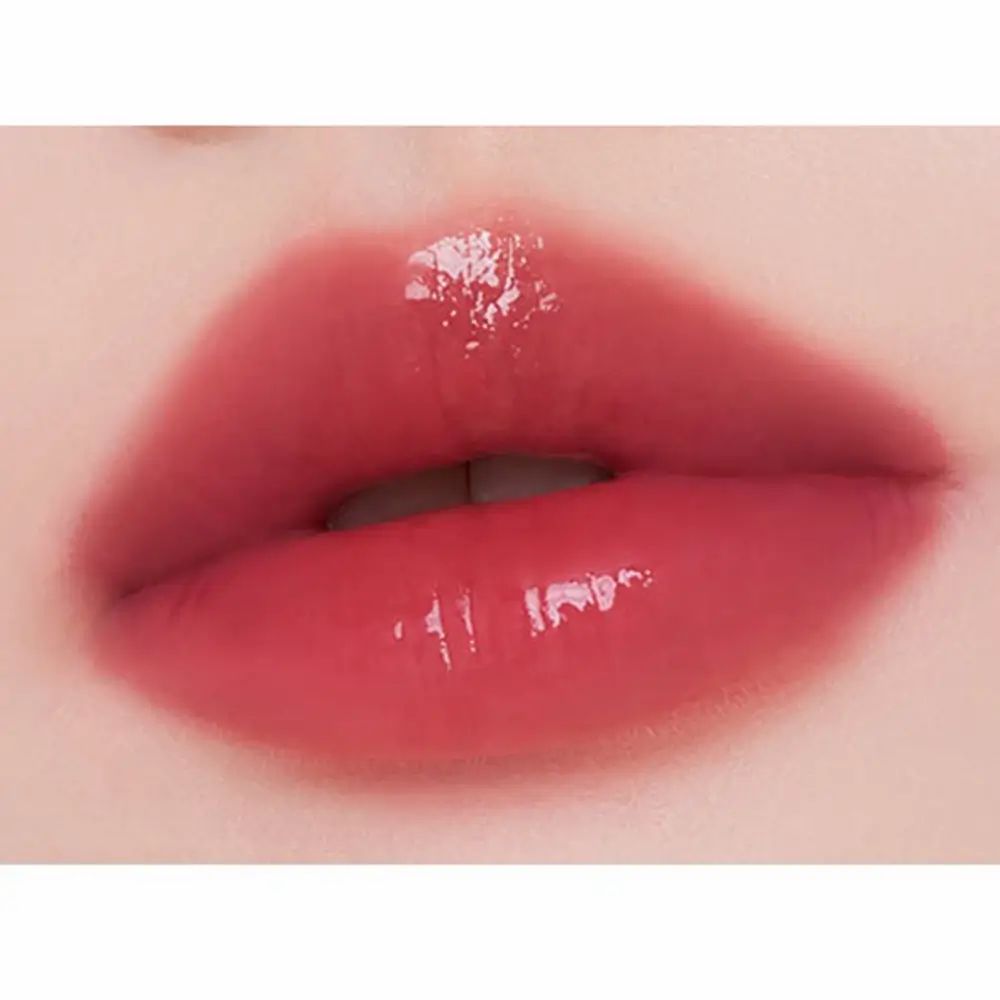 Nahaufnahme von Lippen mit glänzendem, rosafarbenem Lippenstift. Die Lippen sind leicht geöffnet und zeigen eine glatte, glänzende Oberfläche.