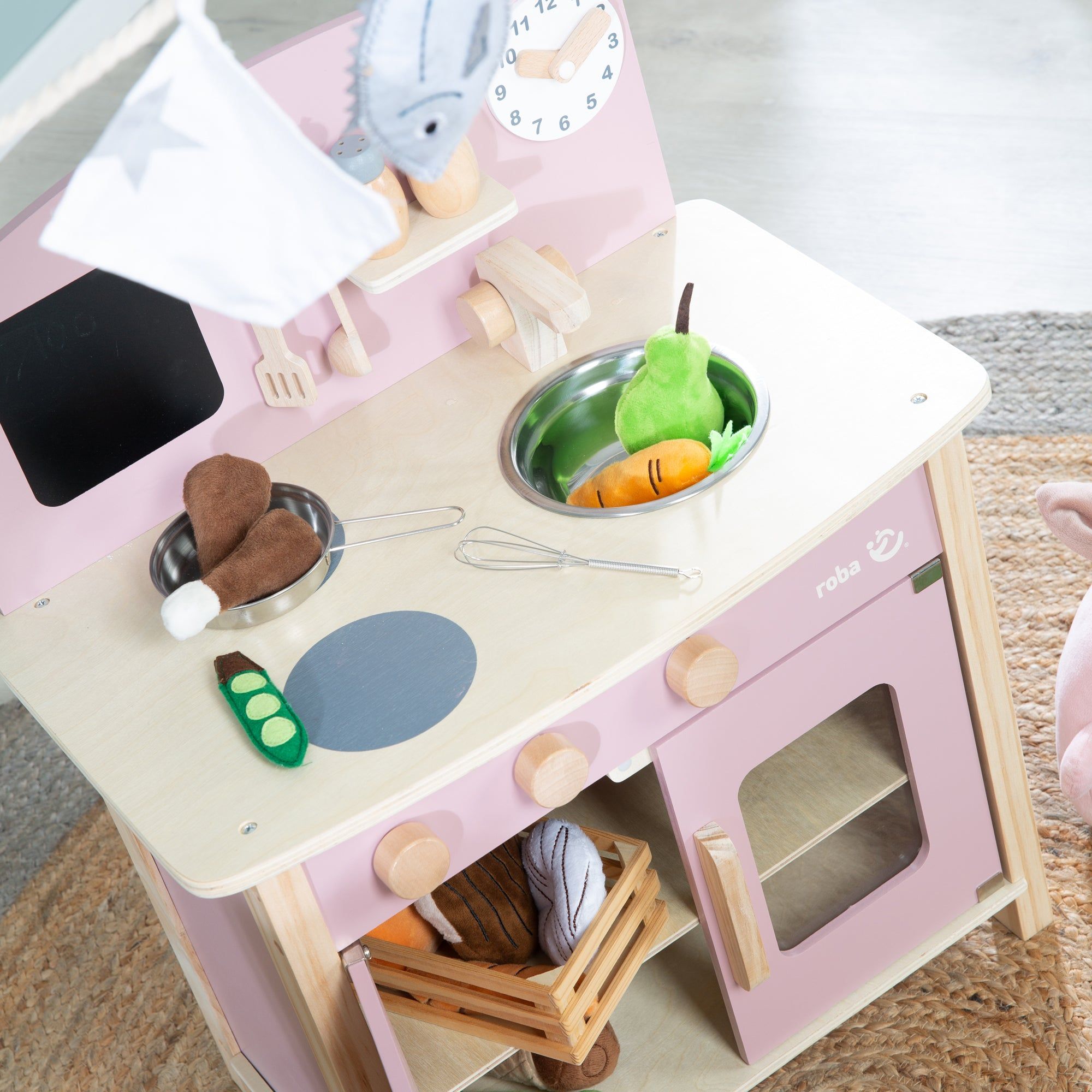 Spielküche mit Zubehör. Rosa lackiertes Holz, helle Arbeitsplatte. Enthält Spielzeug-Lebensmittel und Kochutensilien.