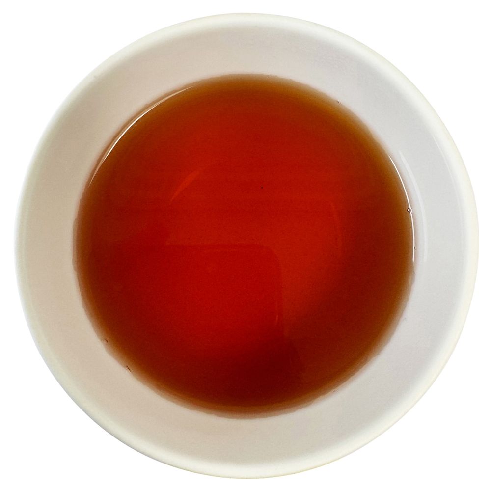 Tee in weißer Schale. Flüssigkeit von rotbrauner Farbe.