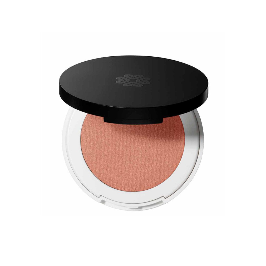 Runder, kompakter Rouge-Puder mit schwarzem Deckel. Der Puder ist pfirsichfarben und in einer weißen Hülle.