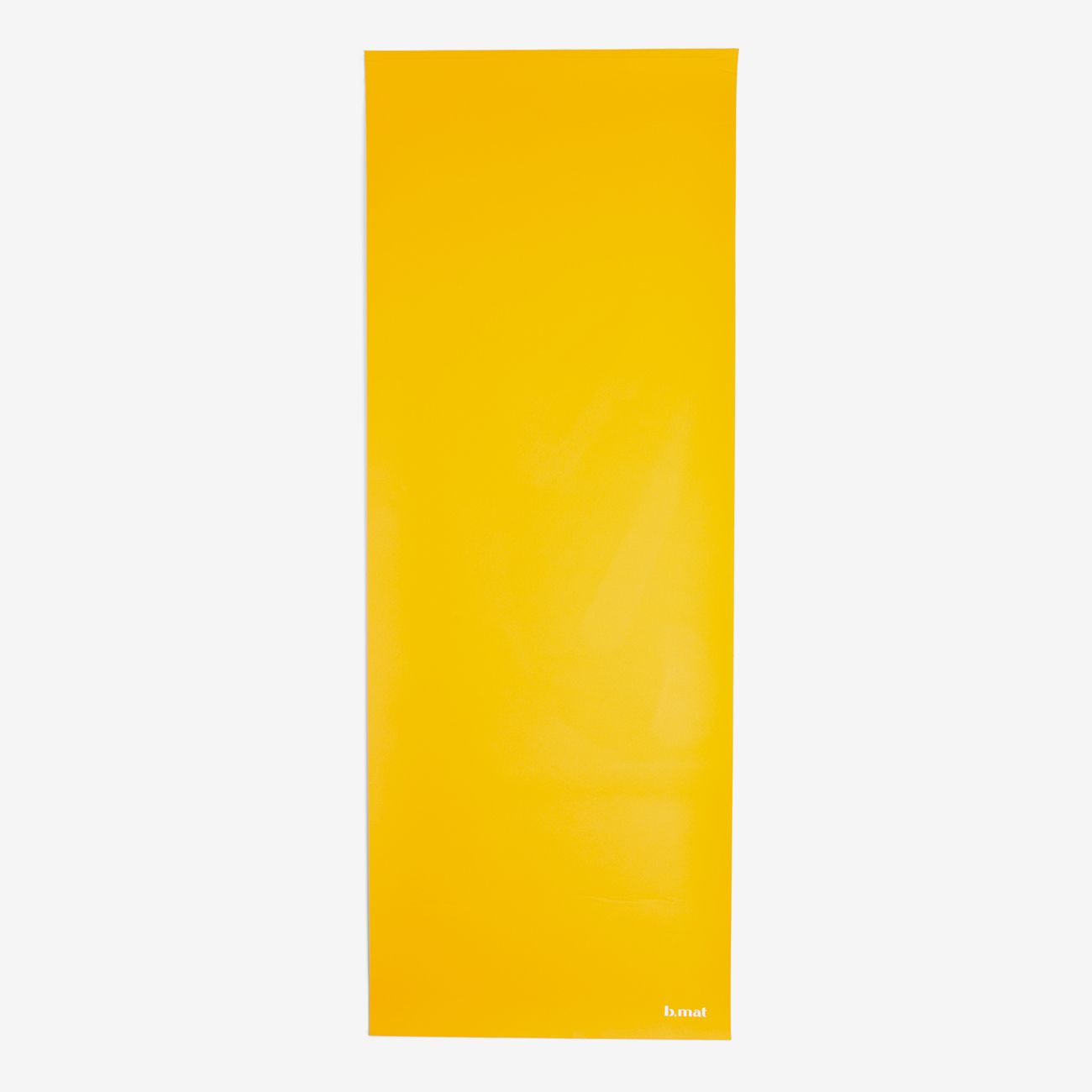 Gelbe Yogamatte, flach ausgebreitet. B MAT-Logo unten rechts. Auf hellem Hintergrund.