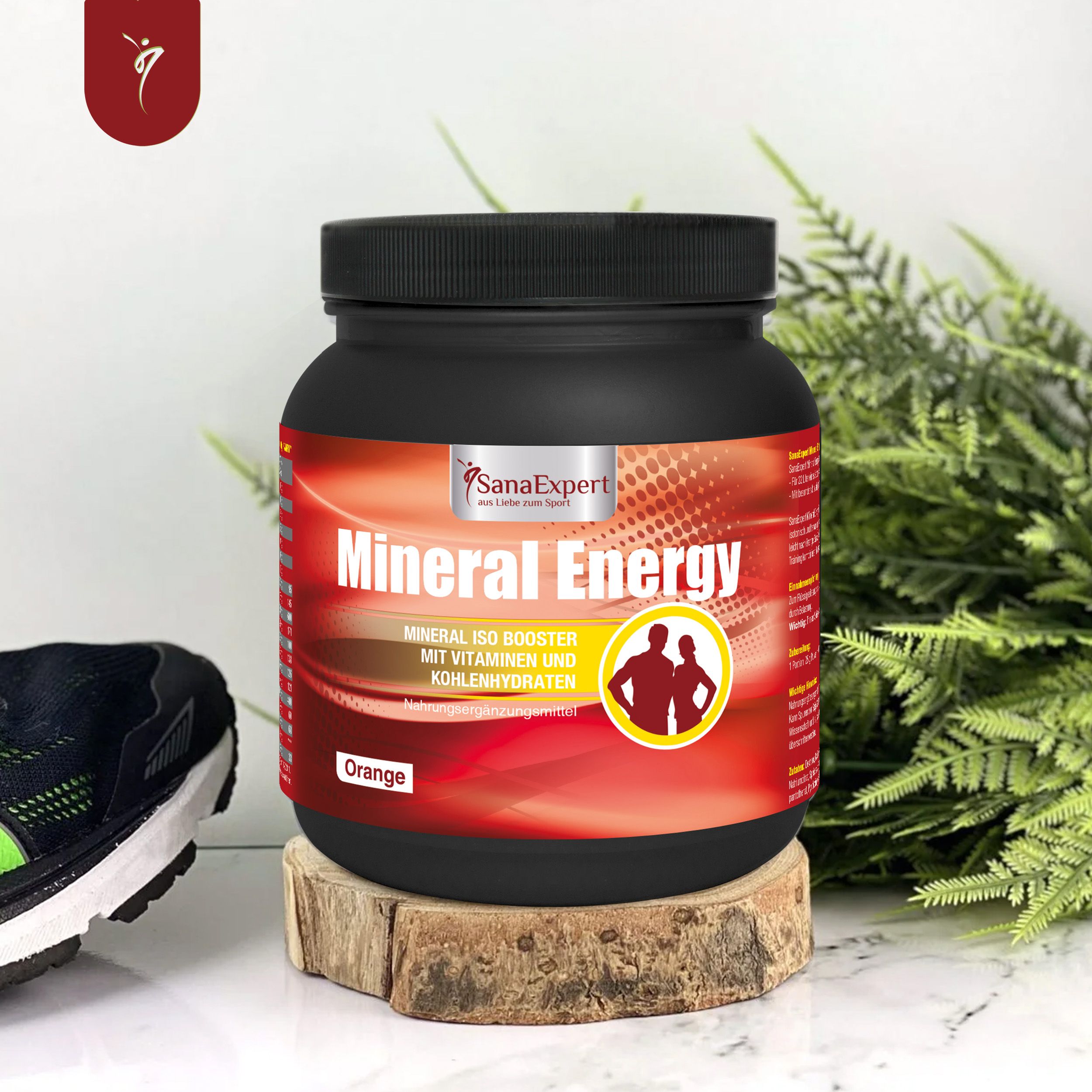 Schwarzer SanaExpert Mineral Energy-Behälter. Orangefarbenes Etikett mit Produktnamen und Logo. Auf Holzblock platziert.