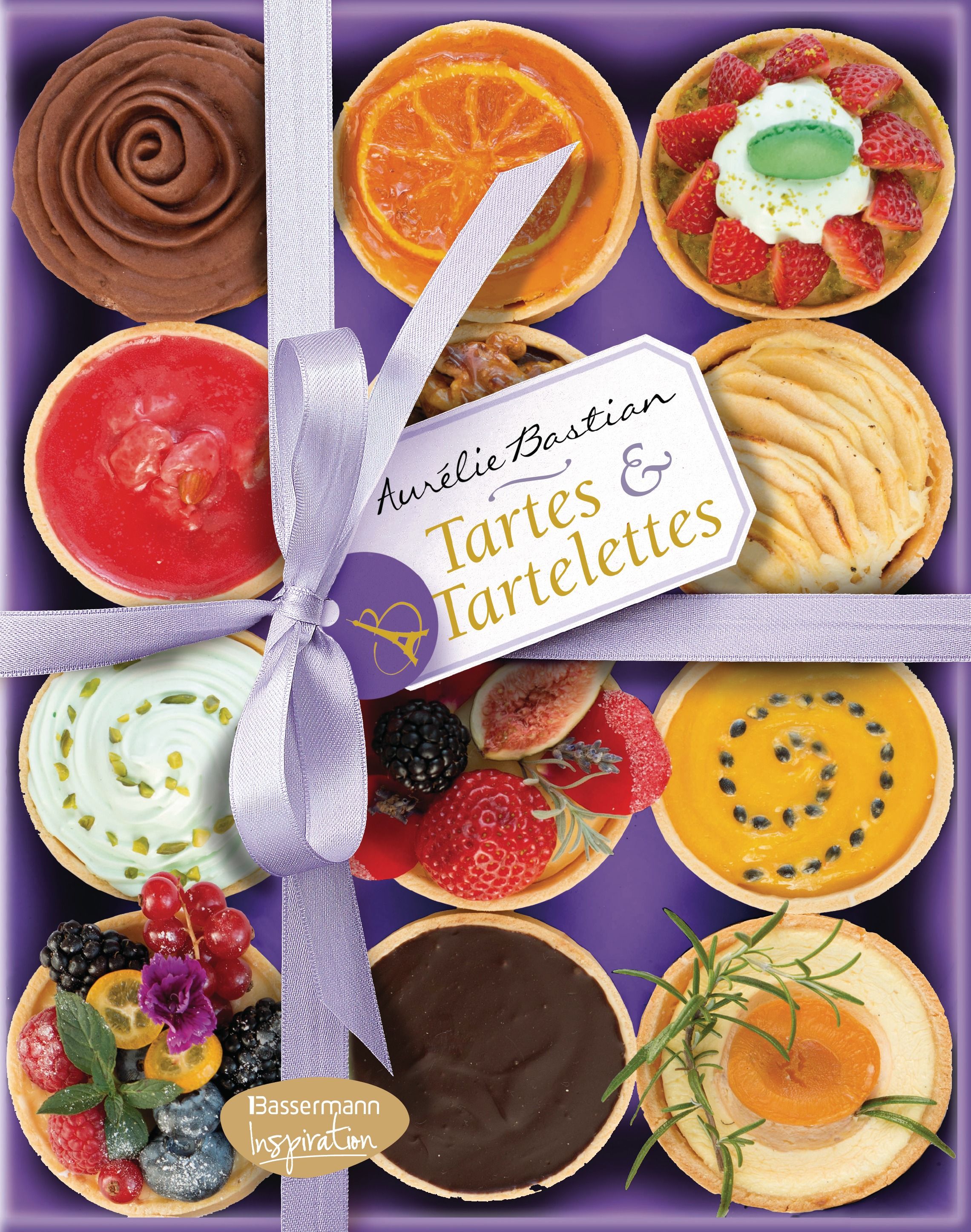 Neun Tartes & Tartelettes in einer lila Schachtel. Dekoriert mit Früchten und Cremes. Mit Schleife und Etikett "Aurélie Bastian".