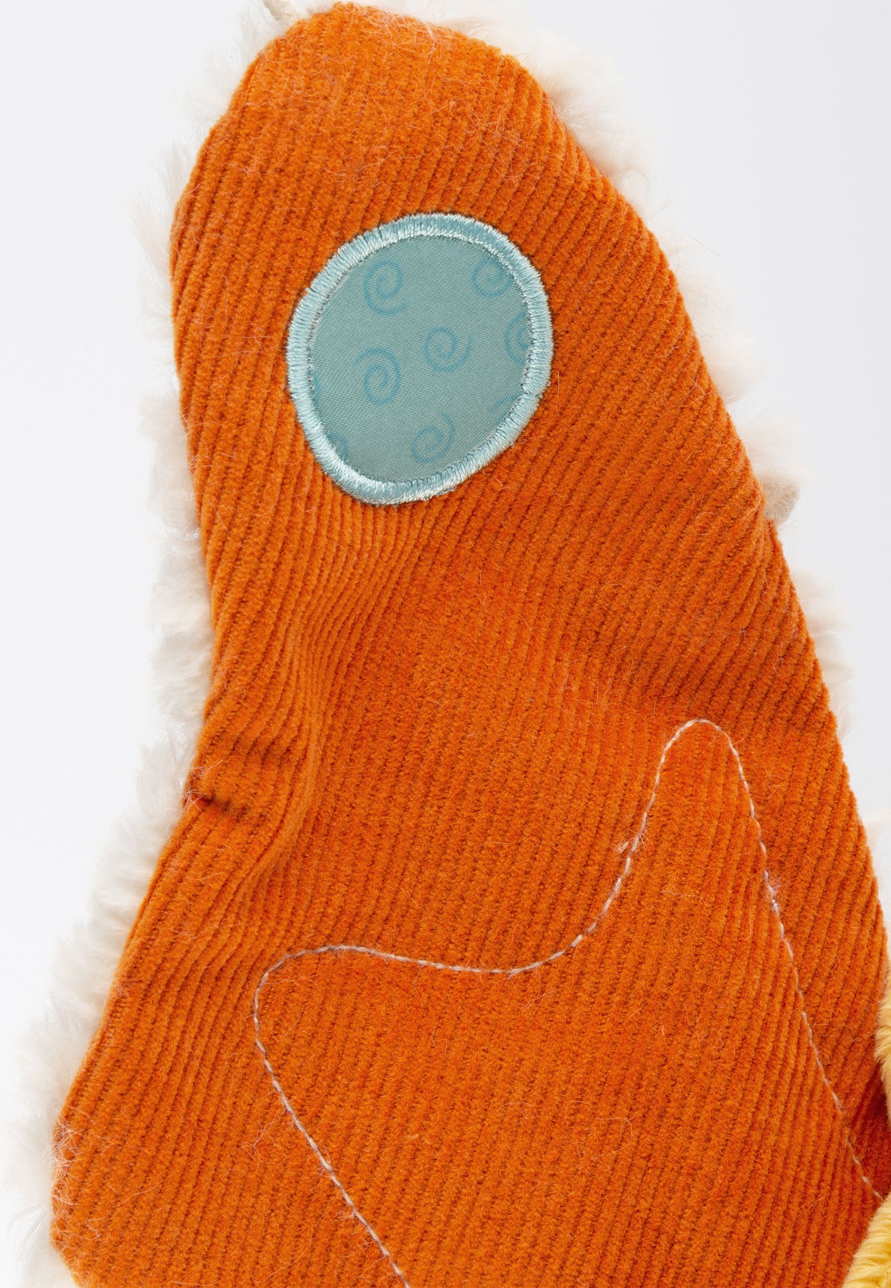 Nahaufnahme eines orangefarbenen Schmetterlingsflügels. Blauer Kreis mit Wirbelmuster. Flauschiger Rand.