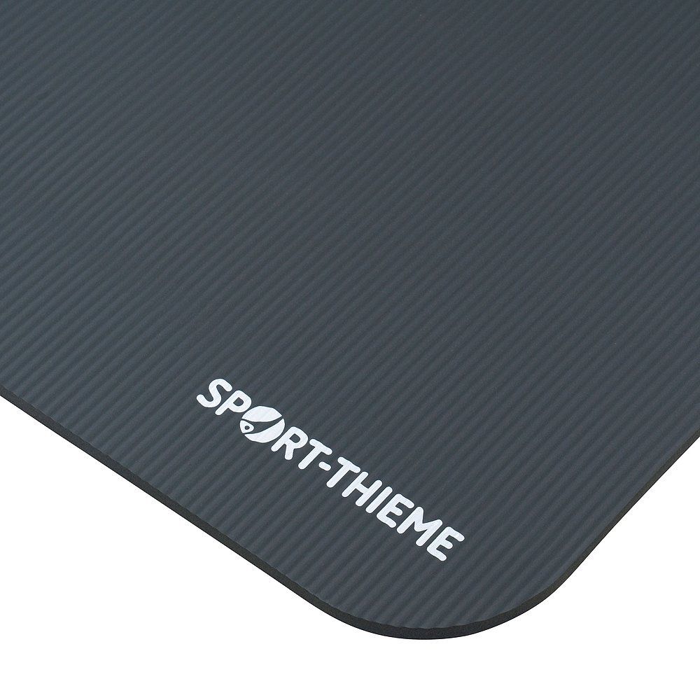 Graue Fitnessmatte mit geriffelter Oberfläche. Abgerundete Ecke mit Sport-Thieme Logo.