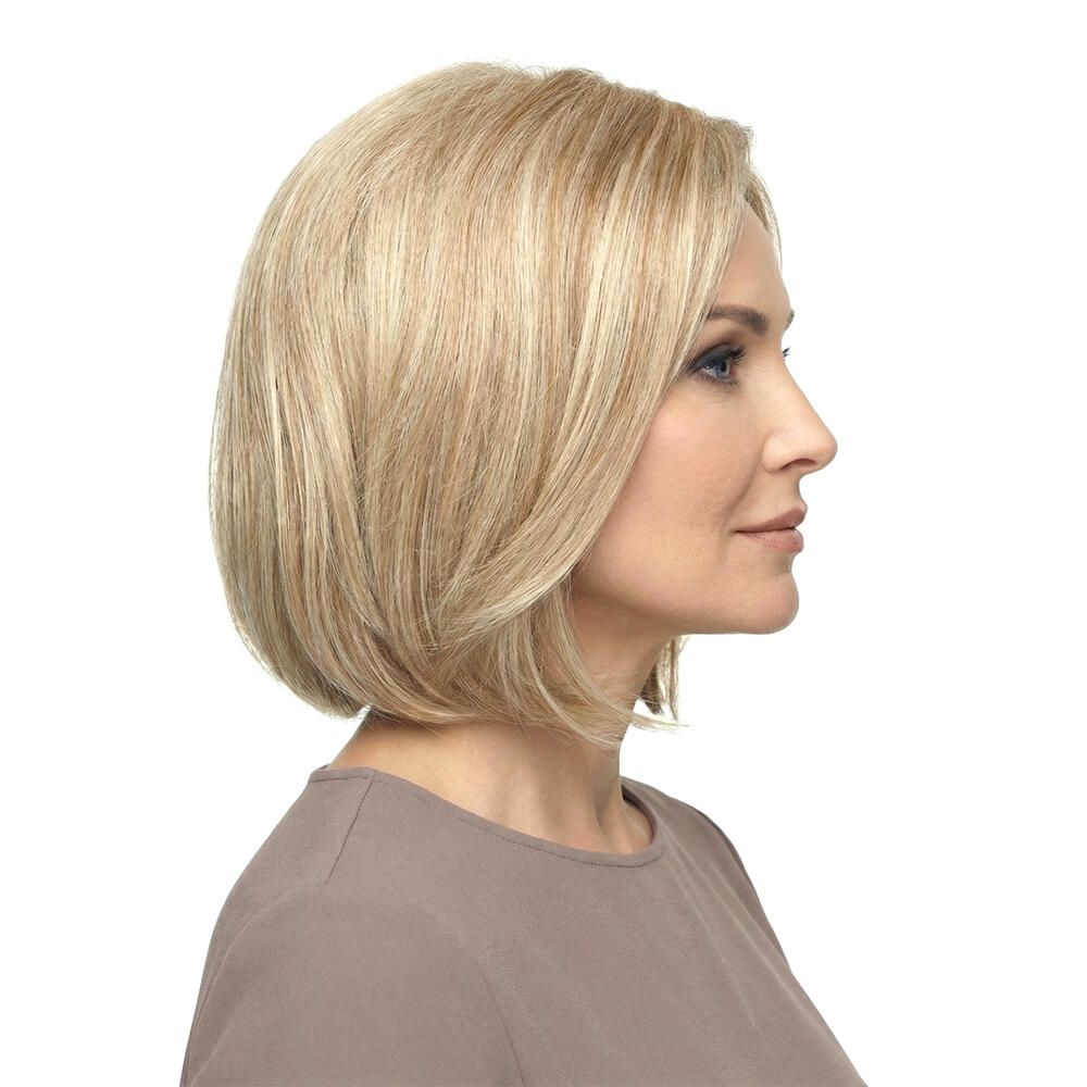 Blonde Perücke mit gestuften Haaren. Seitenansicht einer Frau mit der Perücke. Hellbraunes Oberteil.