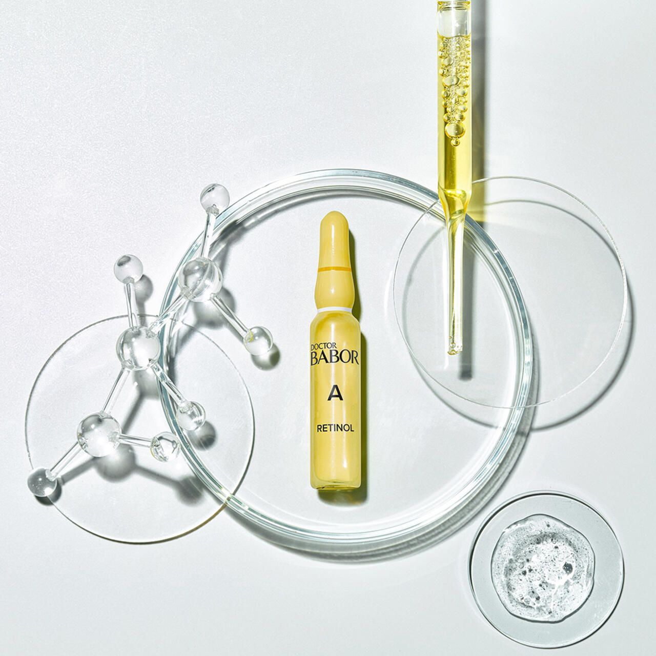 Doctor Babor Power Serum Ampulle Retinol auf Laborutensilien. Ampulle in einer Glasschale, daneben weitere Utensilien.