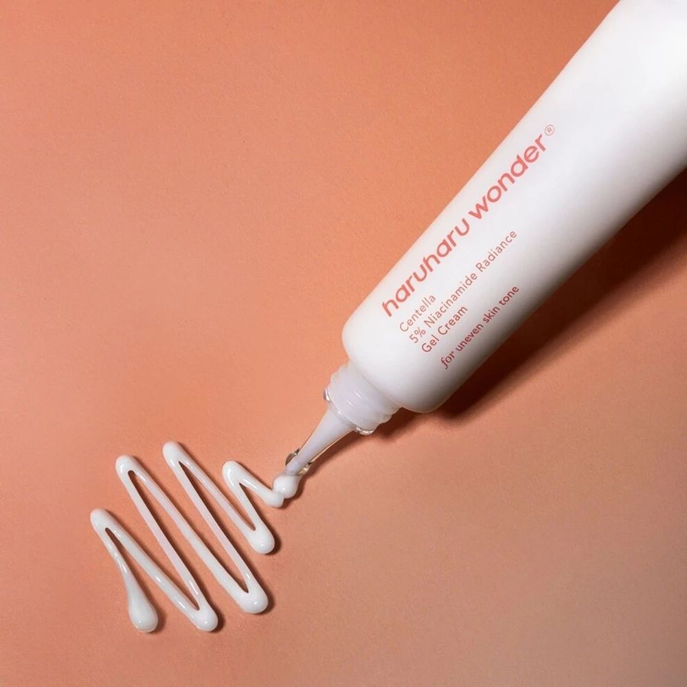 Weiße Tube, Produkt wird herausgedrückt. Text: haruharu wonder, Centella 5% Niacinamide Radiance Gel Cream. Auf rosa Untergrund.