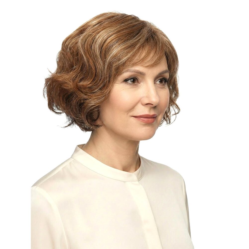 Frau mit brauner Perücke mit Pony. Die Perücke hat blonde Strähnen und welliges Haar. Sie trägt ein weißes Hemd.
