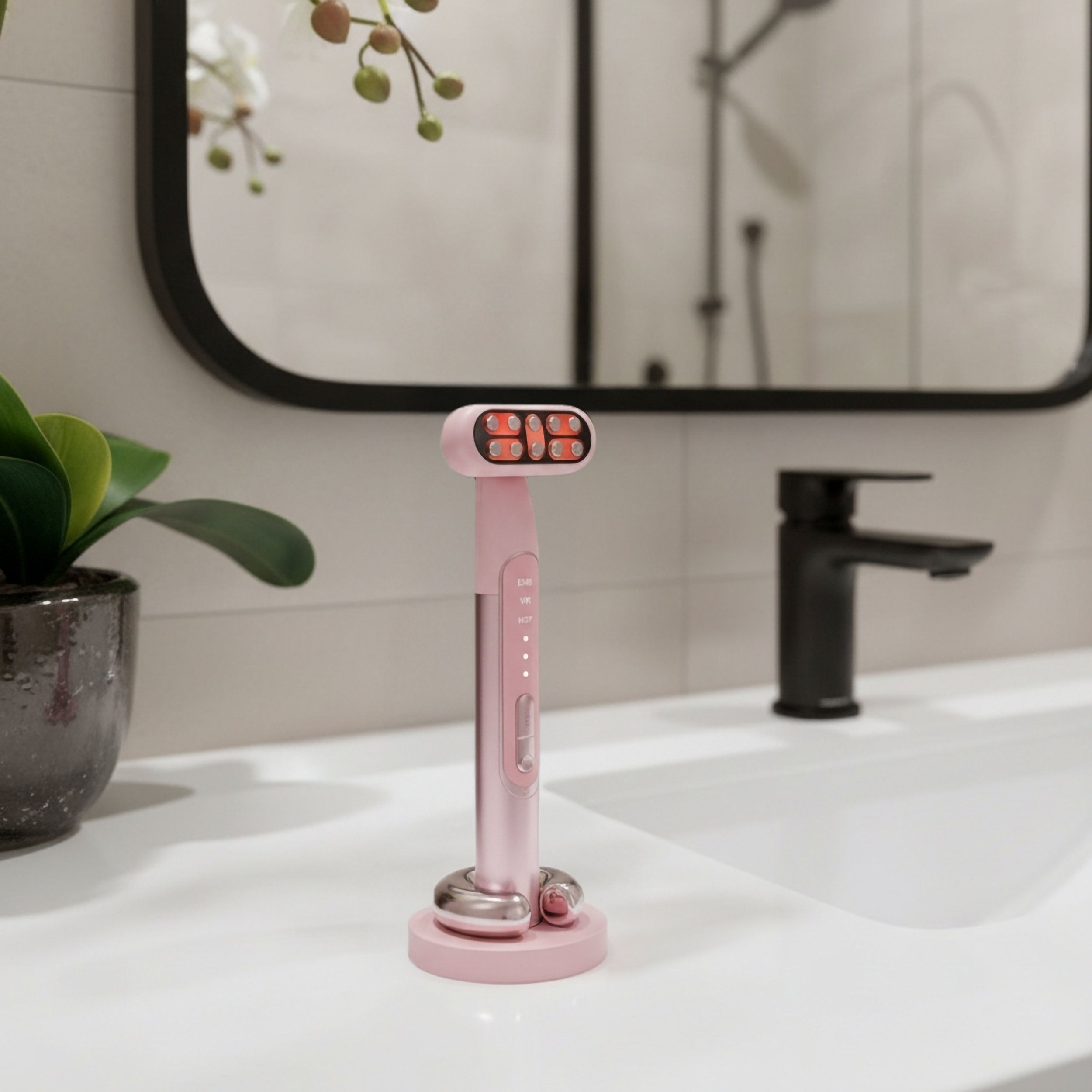 Ein rosa RF EMS LED Anti-Aging-Gerät steht auf seiner Ladebasis auf einem Waschbecken.