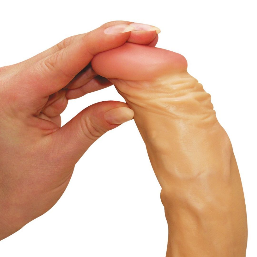 Nahaufnahme eines beigefarbenen Dildos, der von einer Hand gehalten wird.