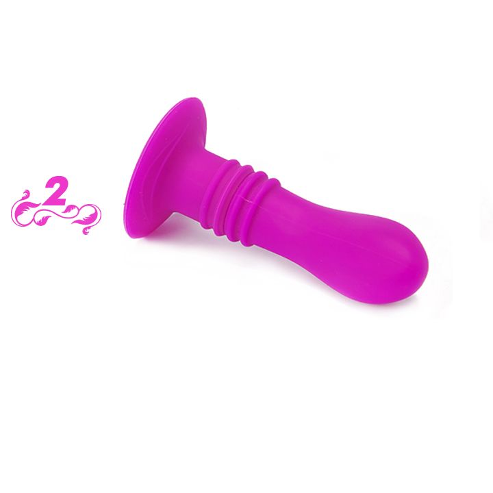 Pinkfarbener Anal Plug mit Saugnapf. Geriffelter Schaft. Auf flacher Oberfläche liegend.