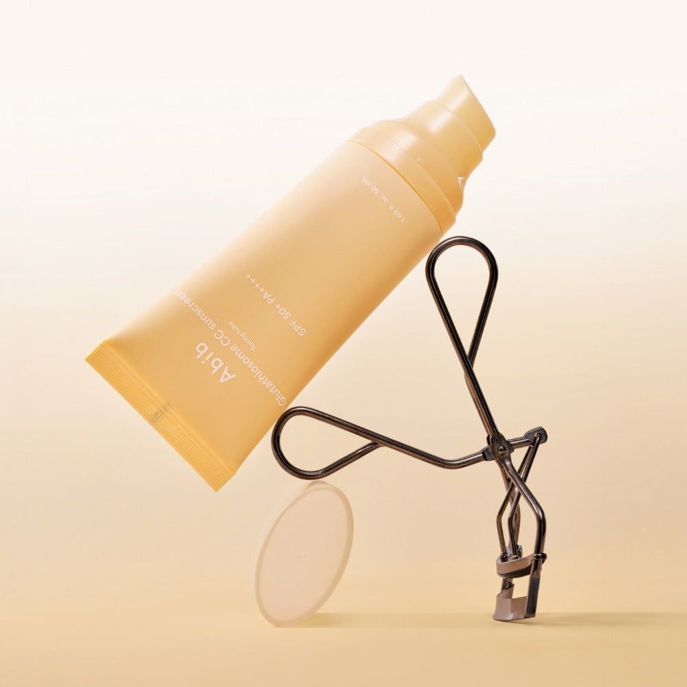 Abib Glutathiosome CC Sonnenschutz Tube neben einem Wimpernformer.