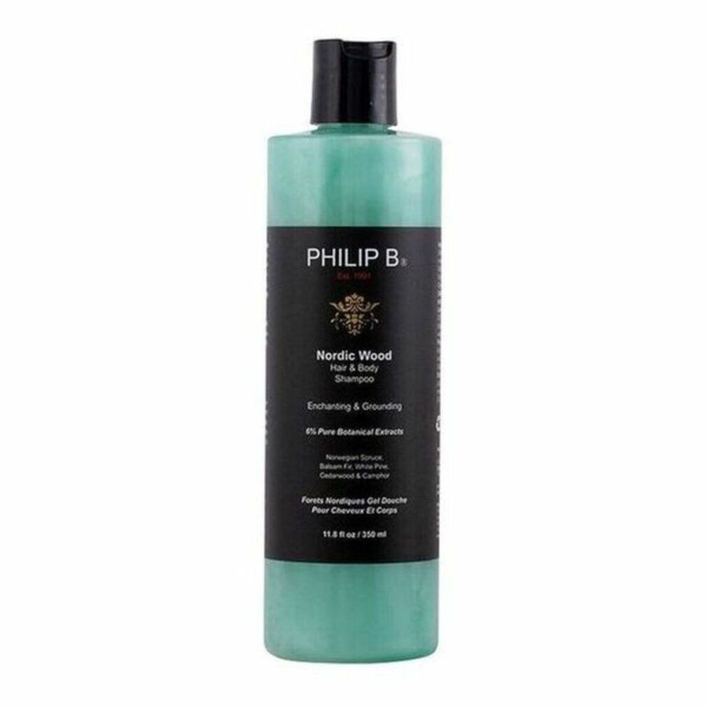 Flasche mit schwarzem Deckel. Aufschrift: PHILIP B. Nordic Wood Hair + Body Shampoo. Grünliche Flüssigkeit sichtbar. Text: Enchanting & Grounding.