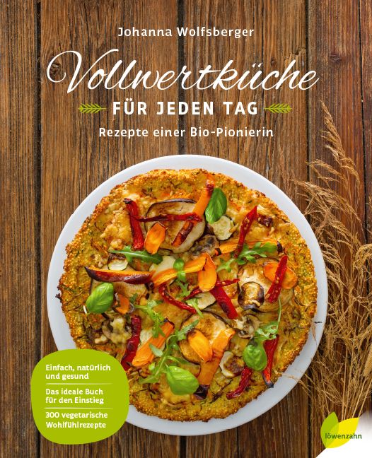 Buchcover mit Titel "Vollwertküche für jeden Tag". Autorin: Johanna Wolfsberger. Auf einem Holztisch liegt eine Pizza mit Gemüse.